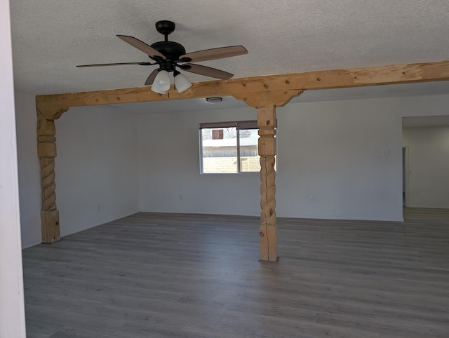 spare room featuring a textured ceiling, a ceiling fan, and wood finished floors