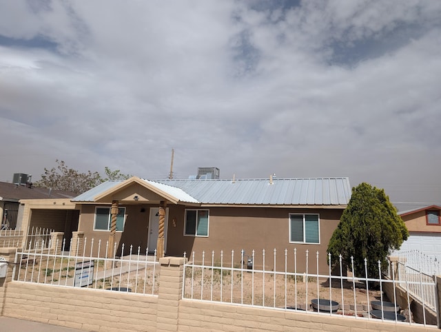 140 65th St NW, Albuquerque, NM 87105 - ranch-style home with stucco siding, a fenced front yard, and metal roof
