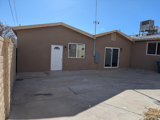 140 65th St NW, Albuquerque, NM 87105 - rear view of house with stucco siding and a patio