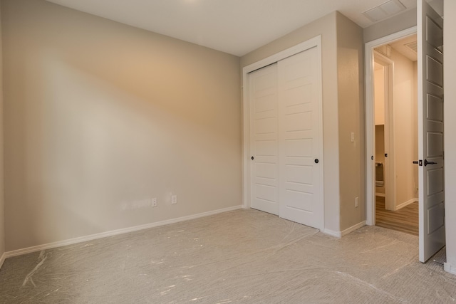 unfurnished bedroom featuring light carpet and a closet