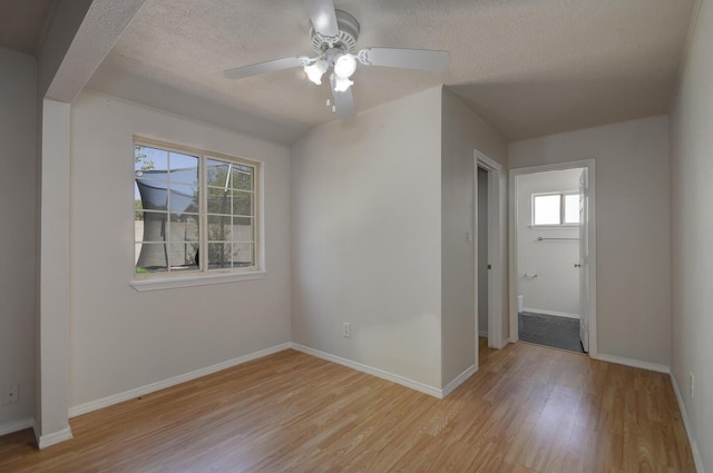 spare room featuring ceiling fan, light hardwood / wood-style flooring, and a textured ceiling