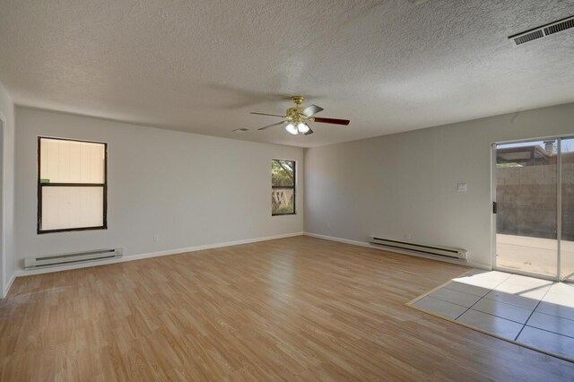 empty room with ceiling fan, light hardwood / wood-style floors, and a baseboard radiator