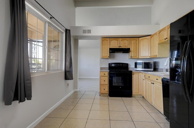 kitchen featuring black appliances, light brown cabinets, light tile patterned flooring, and sink