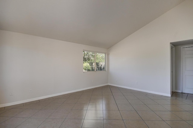 spare room featuring light tile patterned floors and high vaulted ceiling