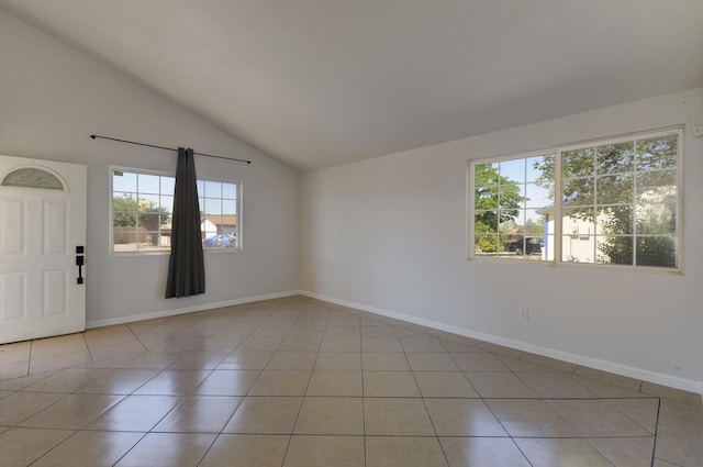 unfurnished room with plenty of natural light, light tile patterned flooring, and vaulted ceiling