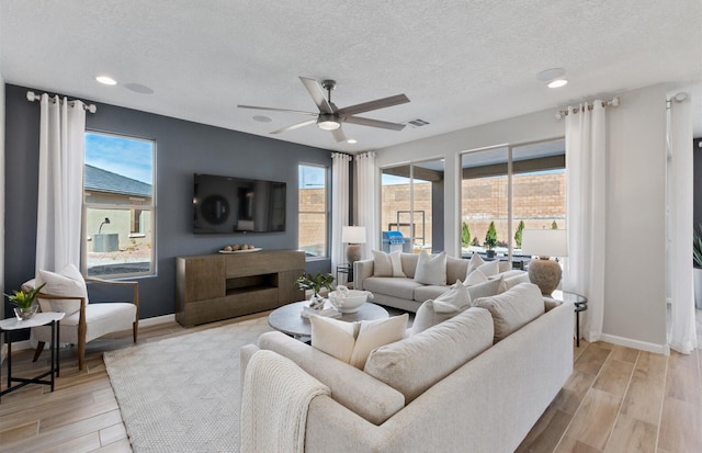 living room with ceiling fan and a textured ceiling