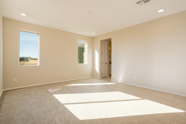 empty room featuring light carpet, baseboards, visible vents, and recessed lighting