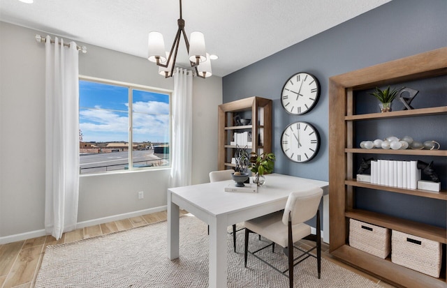 office with light hardwood / wood-style flooring and a chandelier