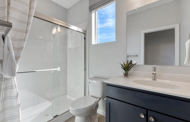 bathroom with hardwood / wood-style floors, vanity, toilet, and a shower with shower door