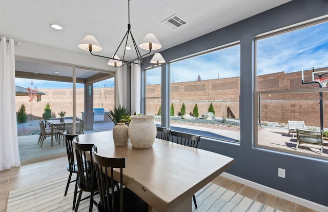 dining area with a chandelier and a textured ceiling