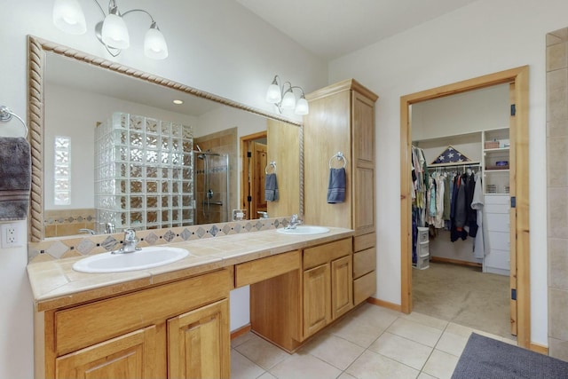 bathroom with tile patterned flooring, vanity, and a shower with door