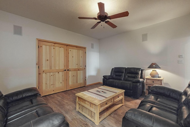 living room with hardwood / wood-style floors, ceiling fan, and a textured ceiling