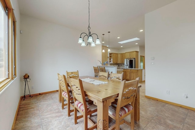 dining space with a skylight and a chandelier