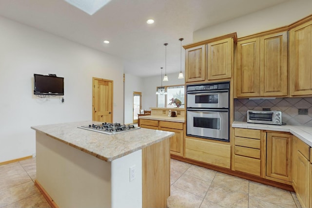 kitchen with light stone countertops, stainless steel appliances, decorative light fixtures, decorative backsplash, and a kitchen island