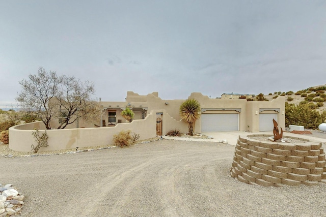 pueblo revival-style home with a garage