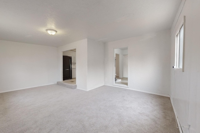 carpeted empty room with a textured ceiling