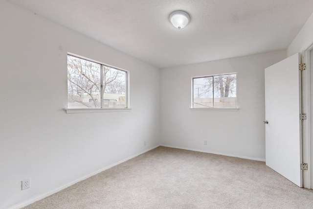 carpeted spare room featuring plenty of natural light