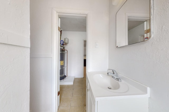 bathroom with strapped water heater, tile patterned floors, and vanity