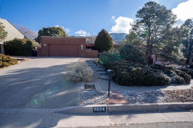 pueblo-style home with a mountain view and a garage