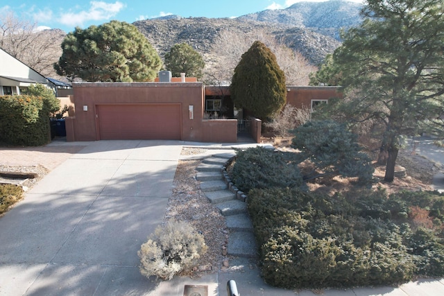 adobe home featuring a mountain view and a garage