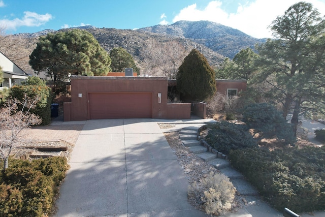 pueblo revival-style home featuring a mountain view and a garage