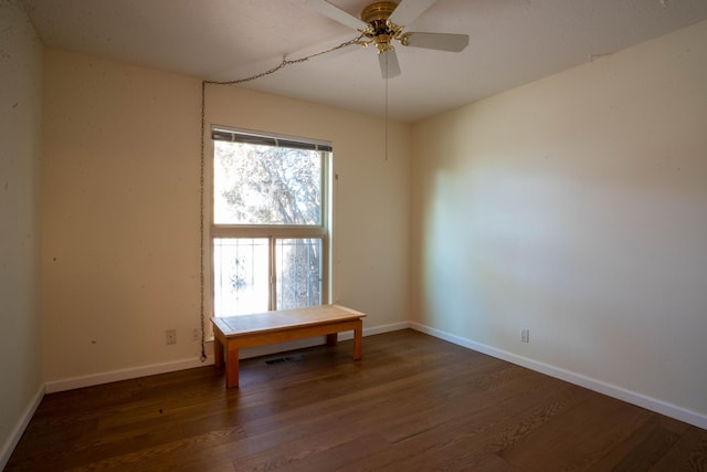 empty room with ceiling fan and dark wood-type flooring