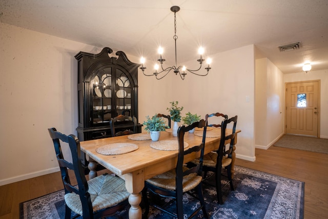 dining space with a notable chandelier and dark hardwood / wood-style floors