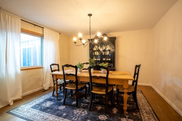 dining room with dark hardwood / wood-style floors and a notable chandelier