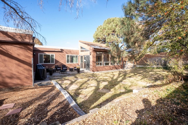 back of property featuring a patio area and a yard