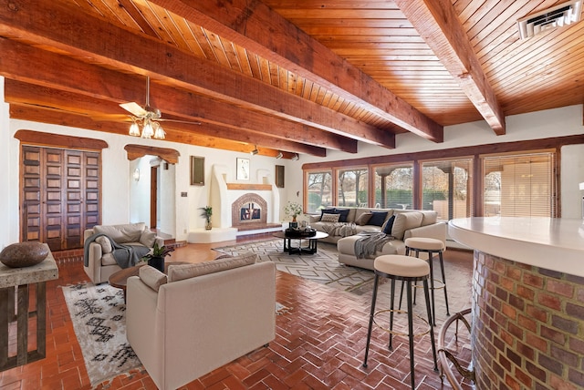 living room featuring beamed ceiling, ceiling fan, and wood ceiling