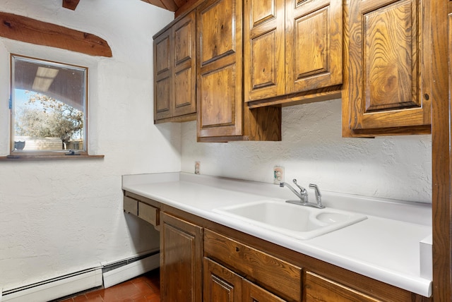 kitchen featuring a baseboard radiator, tile patterned floors, and sink