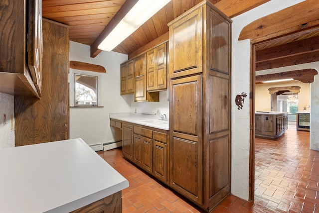 kitchen with wooden ceiling, sink, wine cooler, baseboard heating, and beam ceiling