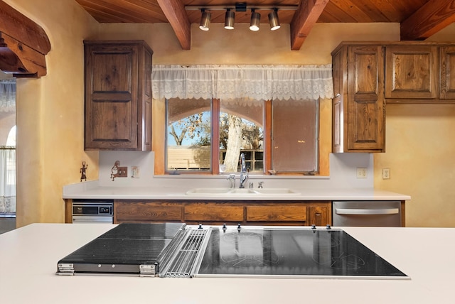 kitchen featuring stainless steel dishwasher, beam ceiling, and wood ceiling