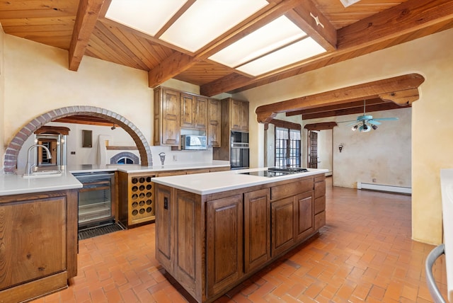 kitchen featuring wooden ceiling, black appliances, a kitchen island, baseboard heating, and beam ceiling