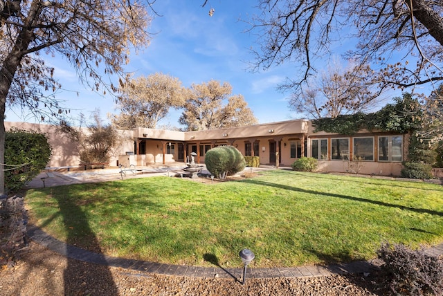 back of house with a patio area and a yard