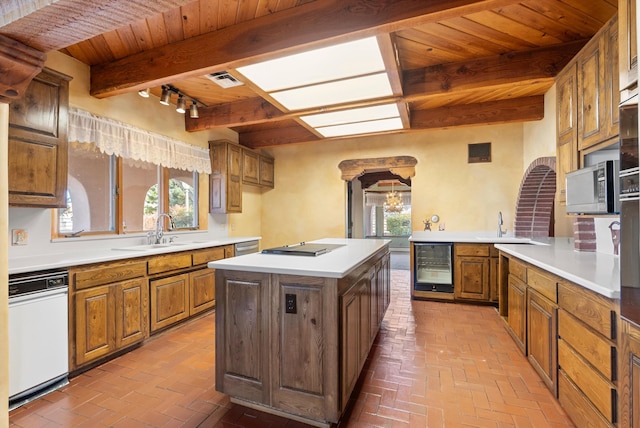 kitchen featuring a healthy amount of sunlight, sink, dishwasher, and beverage cooler