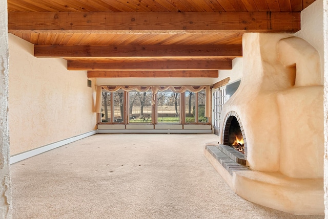 unfurnished living room with a brick fireplace, baseboard heating, beamed ceiling, carpet, and wood ceiling