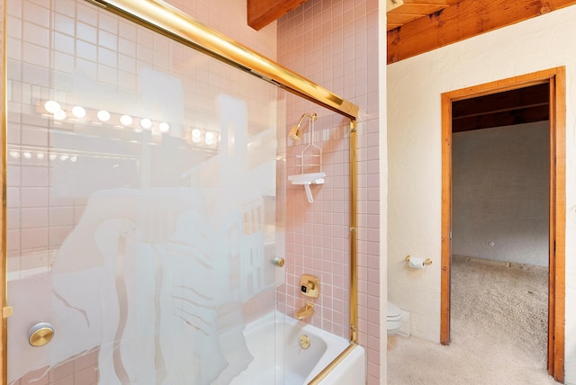 bathroom with toilet and combined bath / shower with glass door