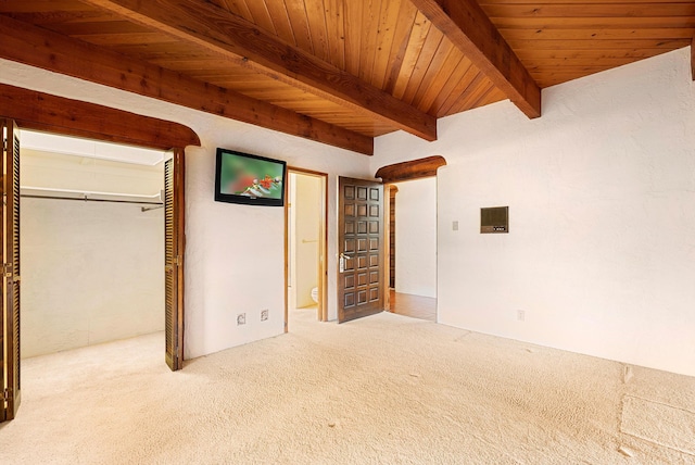 unfurnished bedroom with carpet, ensuite bathroom, wood ceiling, and beamed ceiling