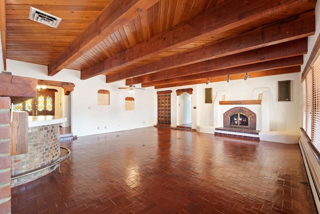 unfurnished living room featuring a brick fireplace, wood ceiling, baseboard heating, ceiling fan, and beamed ceiling