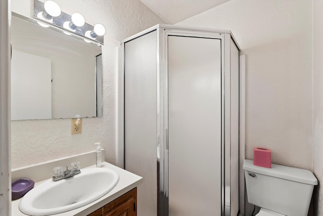 bathroom featuring a textured ceiling, vanity, an enclosed shower, and toilet