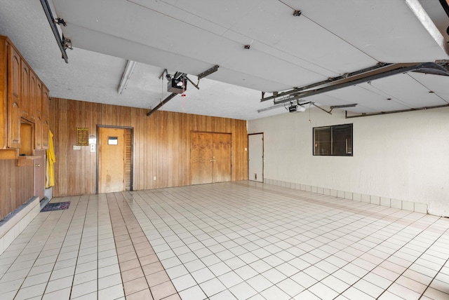 garage with wood walls and a garage door opener