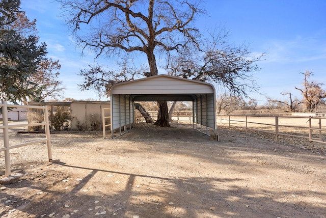 view of outbuilding featuring a rural view and a carport