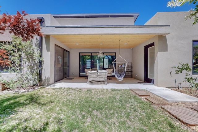 back of house featuring electric panel, a yard, and a patio