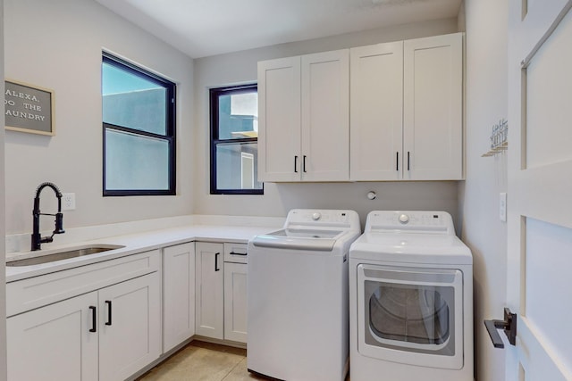 laundry area with cabinets, separate washer and dryer, and sink