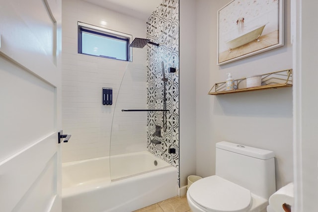 bathroom with tile patterned flooring, tiled shower / bath combo, and toilet