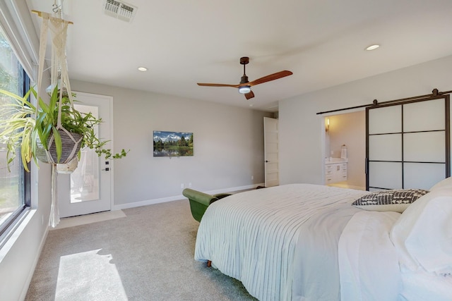 carpeted bedroom featuring ceiling fan and a barn door