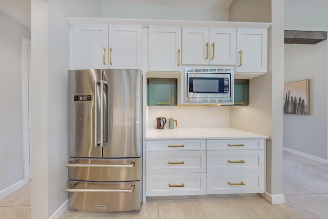 kitchen with white cabinets, light tile patterned floors, and appliances with stainless steel finishes