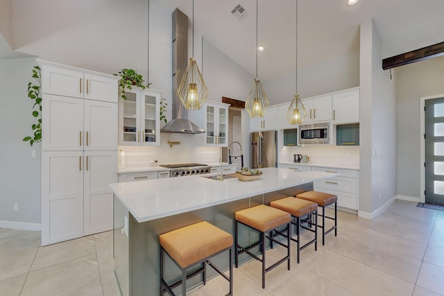 kitchen with a kitchen bar, stainless steel appliances, and a kitchen island with sink