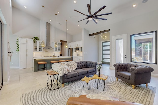 tiled living room with ceiling fan, sink, and high vaulted ceiling